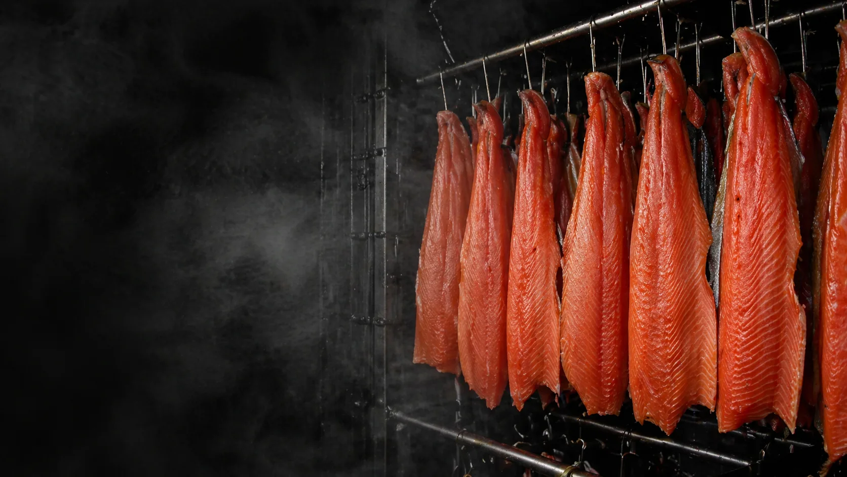 Filets de saumon suspendus dans le fumoir du Saumonier