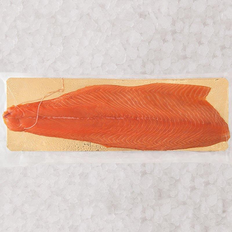 Filet de saumon fumé tranché sur une plaquette dorée