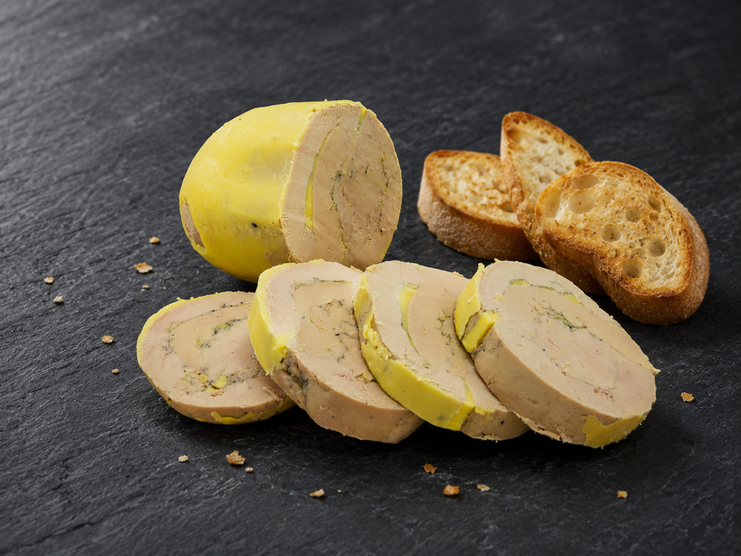 Foie gras maison présenté en tranches sur une ardoise