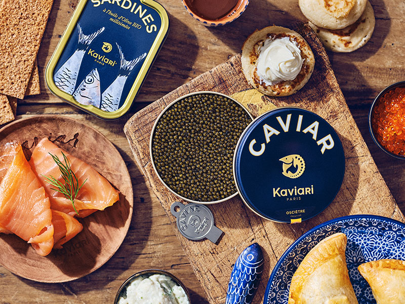 Boîte ouverte de caviar osciètre Kaviari, avec saumon fumé et blinis